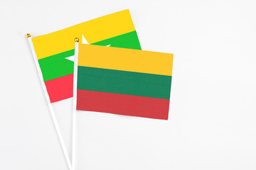 Lithuania and Myanmar stick flags on white background. High quality fabric, miniature national flag. Peaceful global concept.White floor for copy space.