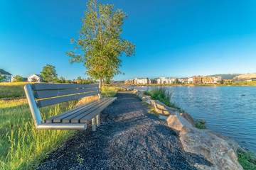 Bench overlooking a rippling lake with homes and buildings in the distance