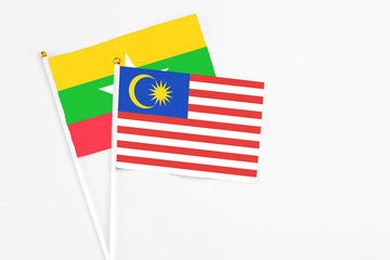 Malaysia and Myanmar stick flags on white background. High quality fabric, miniature national flag. Peaceful global concept.White floor for copy space.
