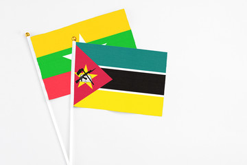 Mozambique and Myanmar stick flags on white background. High quality fabric, miniature national flag. Peaceful global concept.White floor for copy space.