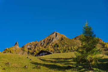 landscape in mountains, hut, peak and blue sky 