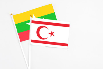 Northern Cyprus and Myanmar stick flags on white background. High quality fabric, miniature national flag. Peaceful global concept.White floor for copy space.