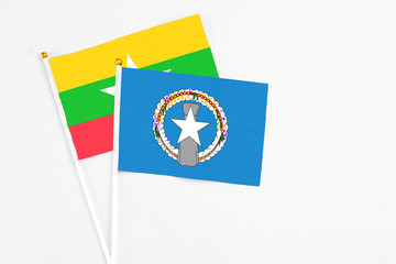 Northern Mariana Islands and Myanmar stick flags on white background. High quality fabric, miniature national flag. Peaceful global concept.White floor for copy space.