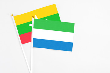Sierra Leone and Myanmar stick flags on white background. High quality fabric, miniature national flag. Peaceful global concept.White floor for copy space.