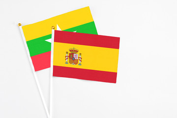 Spain and Myanmar stick flags on white background. High quality fabric, miniature national flag. Peaceful global concept.White floor for copy space.