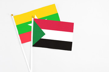 Sudan and Myanmar stick flags on white background. High quality fabric, miniature national flag. Peaceful global concept.White floor for copy space.