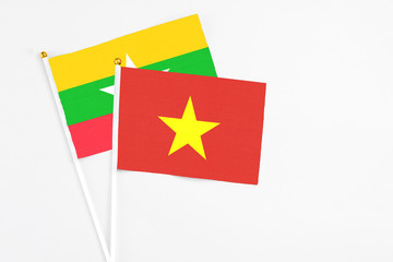 Vietnam and Myanmar stick flags on white background. High quality fabric, miniature national flag. Peaceful global concept.White floor for copy space.