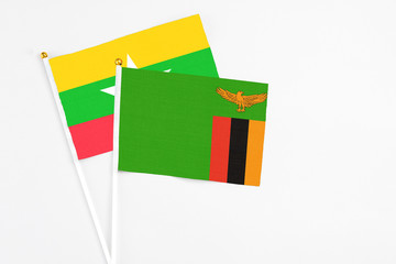 Zambia and Myanmar stick flags on white background. High quality fabric, miniature national flag. Peaceful global concept.White floor for copy space.
