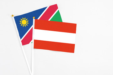 Austria and Namibia stick flags on white background. High quality fabric, miniature national flag. Peaceful global concept.White floor for copy space.
