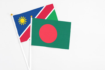 Bangladesh and Namibia stick flags on white background. High quality fabric, miniature national flag. Peaceful global concept.White floor for copy space.