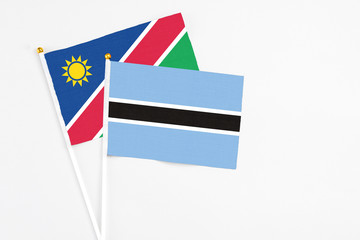 Botswana and Namibia stick flags on white background. High quality fabric, miniature national flag. Peaceful global concept.White floor for copy space.