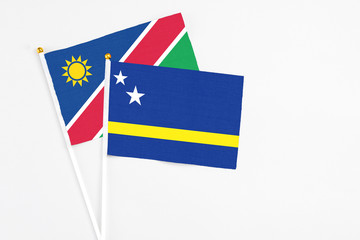 Curacao and Namibia stick flags on white background. High quality fabric, miniature national flag. Peaceful global concept.White floor for copy space.