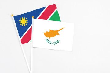 Obraz premium Cyprus and Namibia stick flags on white background. High quality fabric, miniature national flag. Peaceful global concept.White floor for copy space.