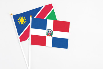 Dominican Republic and Namibia stick flags on white background. High quality fabric, miniature national flag. Peaceful global concept.White floor for copy space.