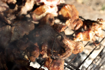 Cooking shish kebabs on the grill on the coals. Appetizing pieces of meat are fried on skewers. Kebabs are fried on coals