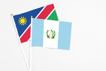Guatemala and Namibia stick flags on white background. High quality fabric, miniature national flag. Peaceful global concept.White floor for copy space.