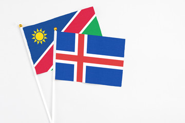 Iceland and Namibia stick flags on white background. High quality fabric, miniature national flag. Peaceful global concept.White floor for copy space.