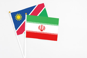 Iran and Namibia stick flags on white background. High quality fabric, miniature national flag. Peaceful global concept.White floor for copy space.