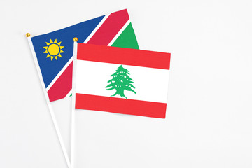 Lebanon and Namibia stick flags on white background. High quality fabric, miniature national flag. Peaceful global concept.White floor for copy space.