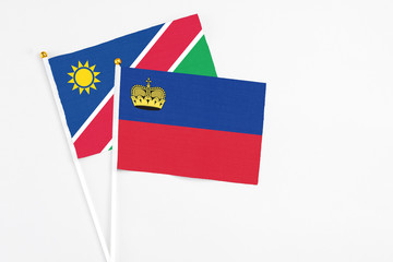 Liechtenstein and Namibia stick flags on white background. High quality fabric, miniature national flag. Peaceful global concept.White floor for copy space.