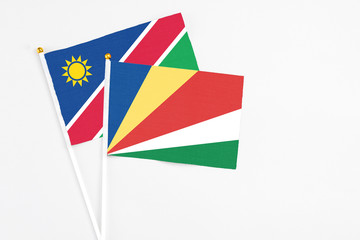 Seychelles and Namibia stick flags on white background. High quality fabric, miniature national flag. Peaceful global concept.White floor for copy space.