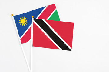 Trinidad And Tobago and Namibia stick flags on white background. High quality fabric, miniature national flag. Peaceful global concept.White floor for copy space.