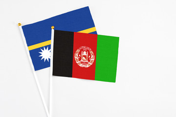 Afghanistan and Nauru stick flags on white background. High quality fabric, miniature national...