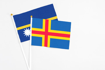 Aland Islands and Nauru stick flags on white background. High quality fabric, miniature national...