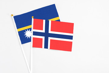 Bouvet Islands and Nauru stick flags on white background. High quality fabric, miniature national flag. Peaceful global concept.White floor for copy space.