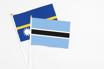 Botswana and Nauru stick flags on white background. High quality fabric, miniature national flag....