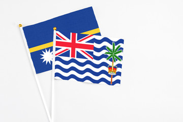 Fototapeta premium British Indian Ocean Territory and Nauru stick flags on white background. High quality fabric, miniature national flag. Peaceful global concept.White floor for copy space.