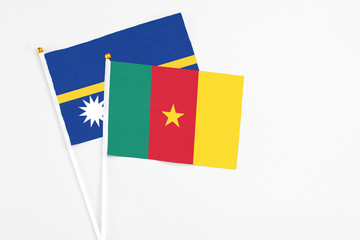 Cameroon and Nauru stick flags on white background. High quality fabric, miniature national flag. Peaceful global concept.White floor for copy space.