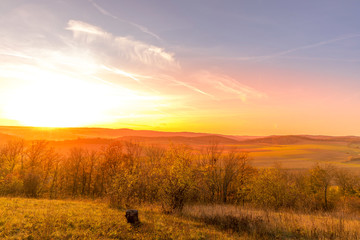 Sunset overlooking nature and landscape from Brno hill sunset couple of moments before sunset orange color with clouds moving in the background and planes flying in the sky.