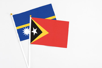 East Timor and Nauru stick flags on white background. High quality fabric, miniature national flag....
