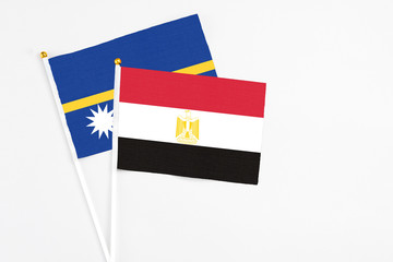 Egypt and Nauru stick flags on white background. High quality fabric, miniature national flag. Peaceful global concept.White floor for copy space.