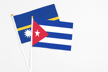 Cuba and Nauru stick flags on white background. High quality fabric, miniature national flag. Peaceful global concept.White floor for copy space.