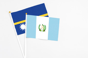 Guatemala and Nauru stick flags on white background. High quality fabric, miniature national flag....
