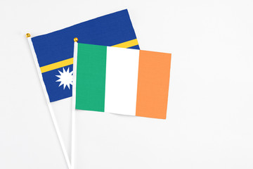 Ireland and Nauru stick flags on white background. High quality fabric, miniature national flag. Peaceful global concept.White floor for copy space.