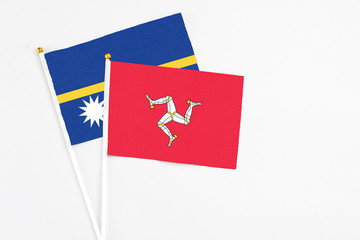 Isle Of Man and Nauru stick flags on white background. High quality fabric, miniature national flag. Peaceful global concept.White floor for copy space.
