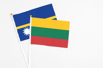 Lithuania and Nauru stick flags on white background. High quality fabric, miniature national flag. Peaceful global concept.White floor for copy space.