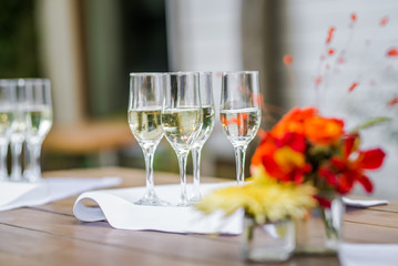 Wine glasses ready for a catering service and a bouquet of flowers.