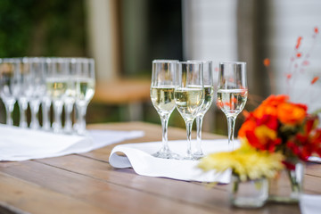 Wine glasses ready for a catering service and a bouquet of flowers.