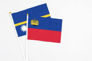 Liechtenstein and Nauru stick flags on white background. High quality fabric, miniature national flag. Peaceful global concept.White floor for copy space.