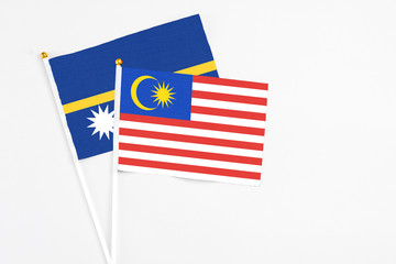 Malaysia and Nauru stick flags on white background. High quality fabric, miniature national flag. Peaceful global concept.White floor for copy space.