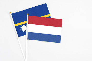 Netherlands and Nauru stick flags on white background. High quality fabric, miniature national...