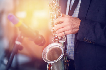 Jazz man musician playing saxophone with sun light