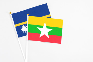 Myanmar and Nauru stick flags on white background. High quality fabric, miniature national flag. Peaceful global concept.White floor for copy space.