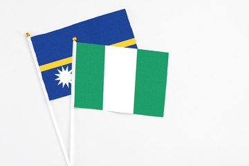 Nigeria and Nauru stick flags on white background. High quality fabric, miniature national flag. Peaceful global concept.White floor for copy space.