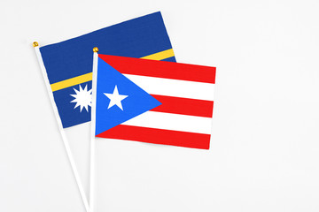 Puerto Rico and Nauru stick flags on white background. High quality fabric, miniature national flag. Peaceful global concept.White floor for copy space.