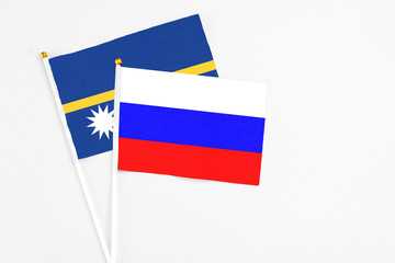 Russia and Nauru stick flags on white background. High quality fabric, miniature national flag....